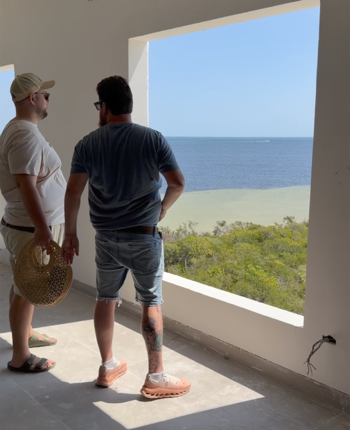 Craig and the Vista Esmeralda owners on-site, looking out at the Gulf of Mexico from a unit under construction
